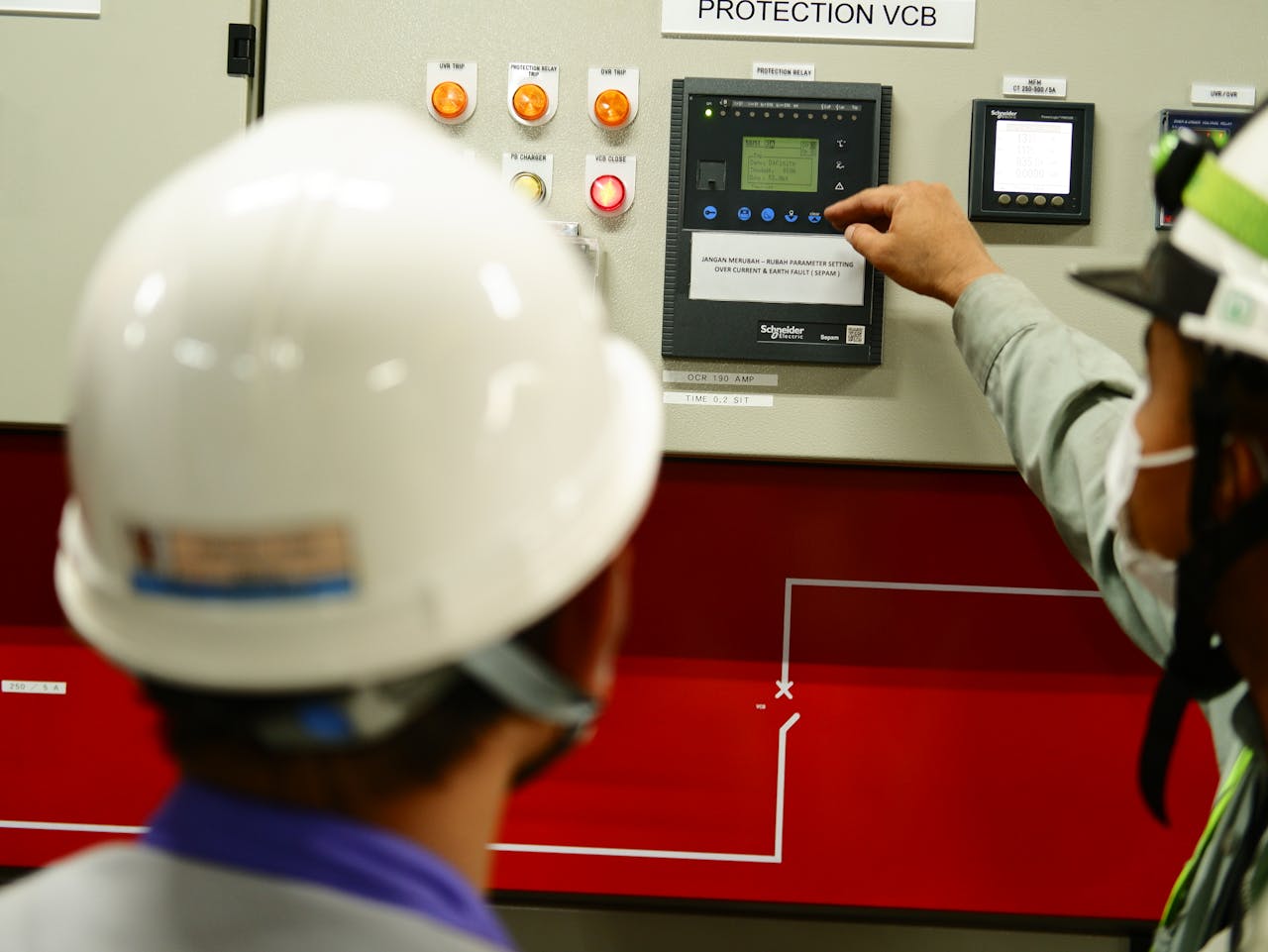 awards-img Engineers wearing safety gear operate a control panel in an Indonesian facility.